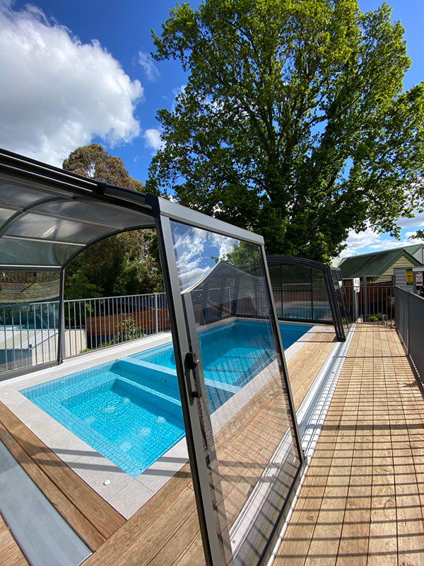 A Pool Enclosure In Sydney Prevents Leaves From A Neighbours Tree