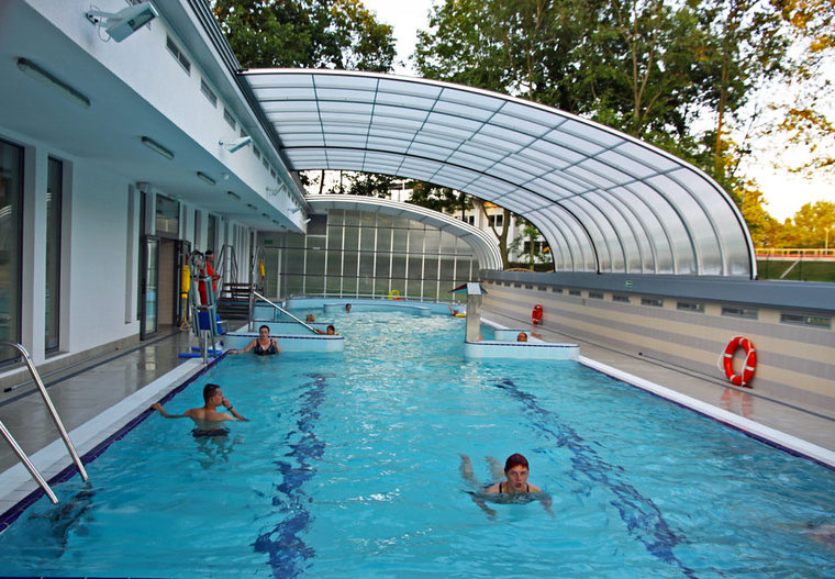 A swim school with a retractable pool enclosure that is semi open