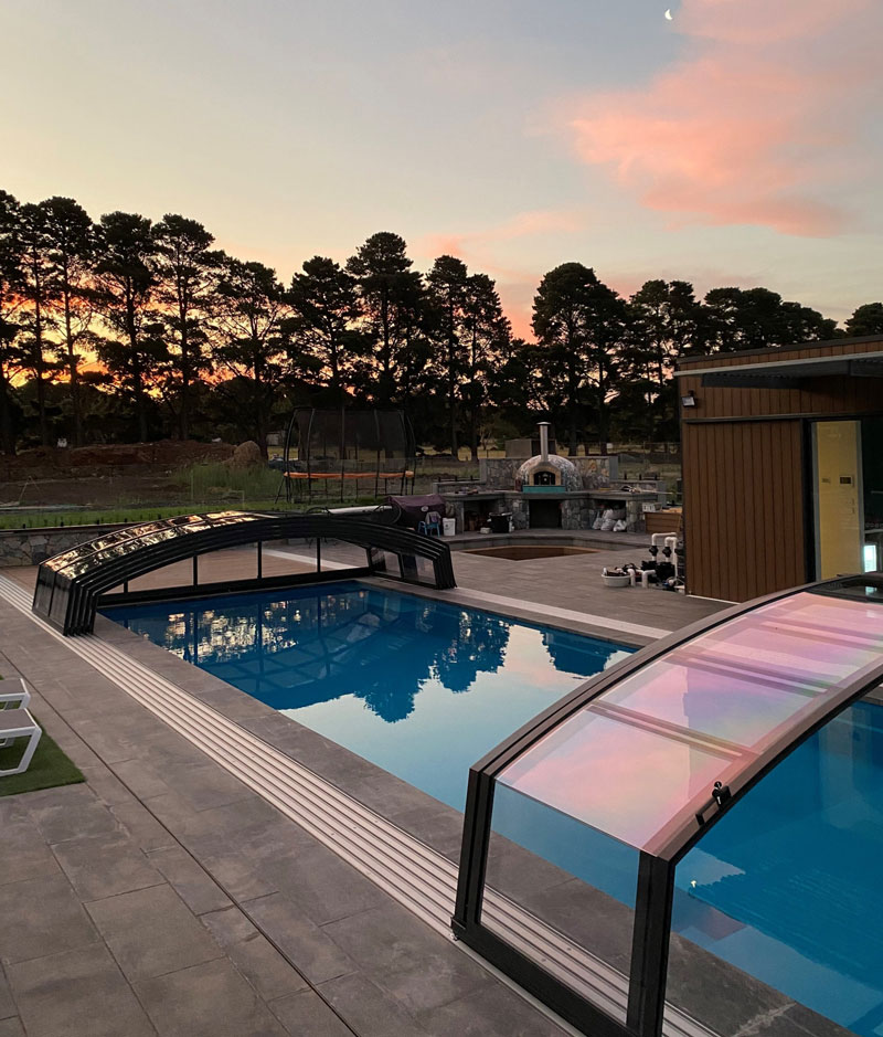 A low height pool enclosure with recessed track at sunset